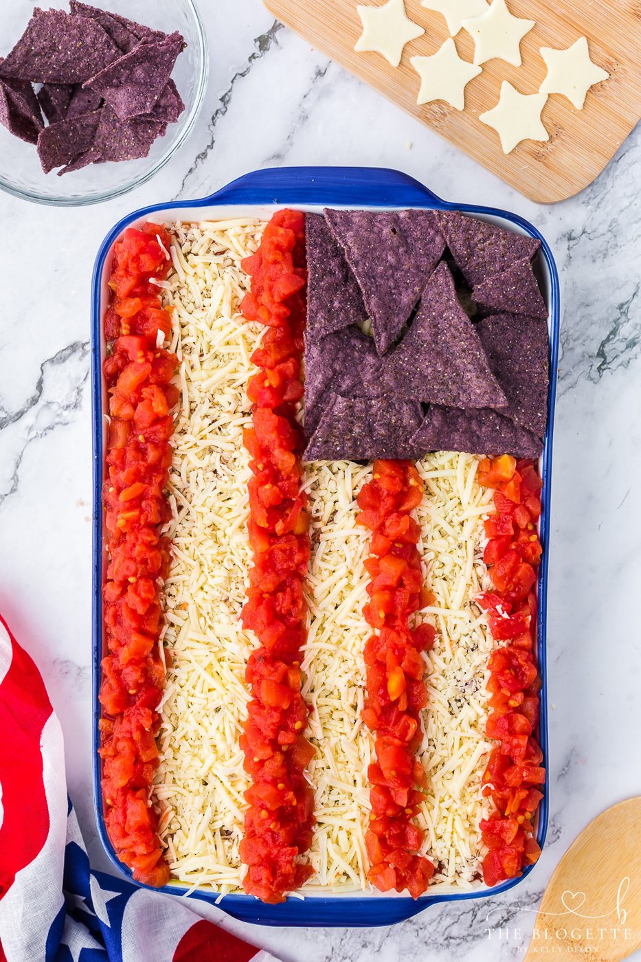 Add blue chips and red tomato stripes over the white cheese