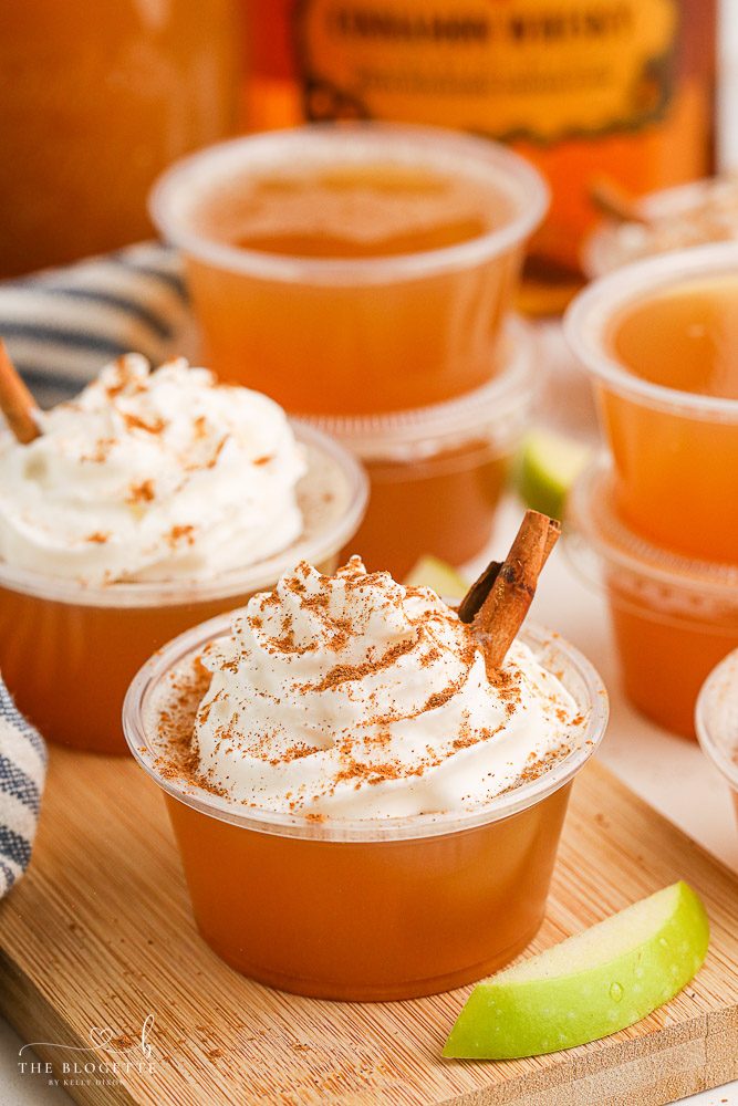 Apple Pie Jello Shots made with Fireball! Topped with whipped cream, this festive jello shot is well-balanced for the holidays or any fall gathering!