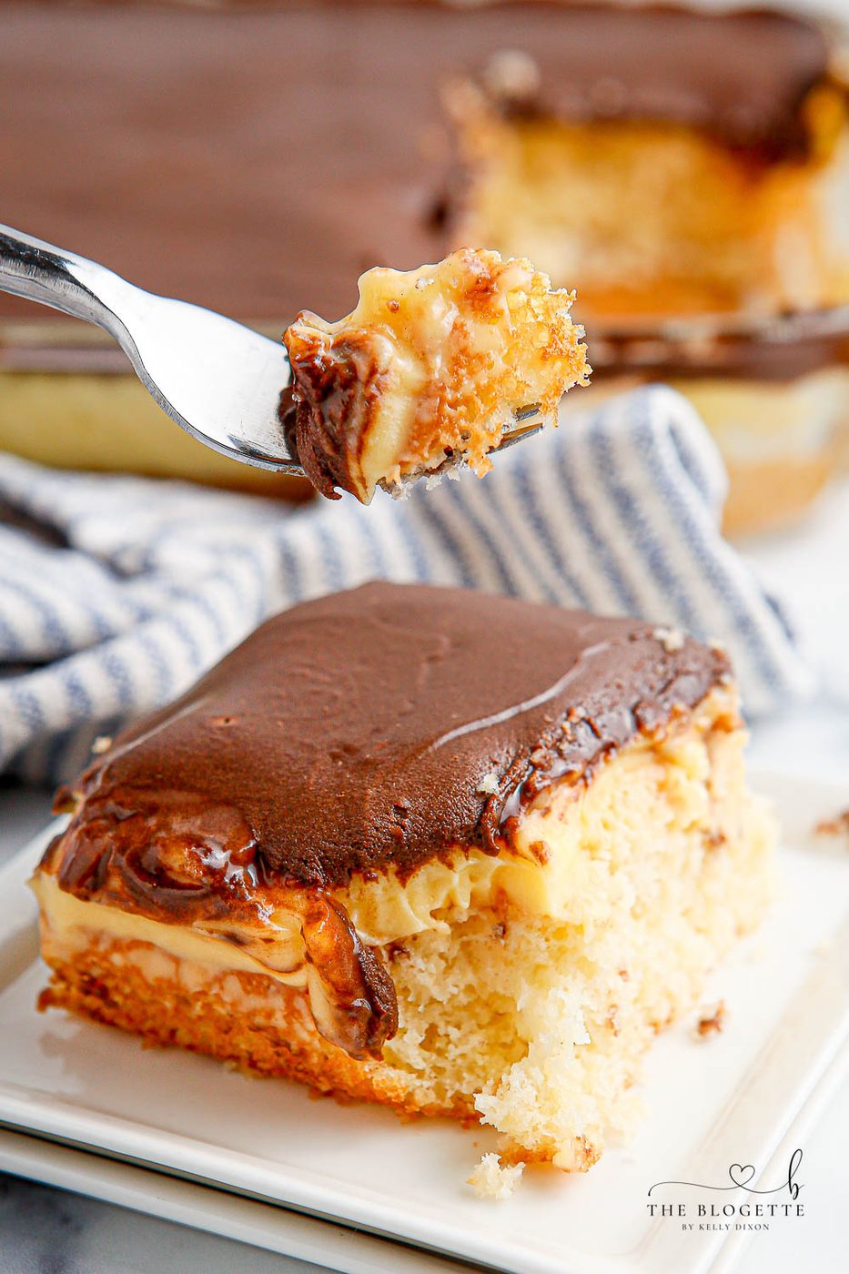 Boston Cream Poke Cake is so simple to whip up. With cake, pudding, and chocolate frosting, this cake is a speedy spin on Boston Cream Pie!