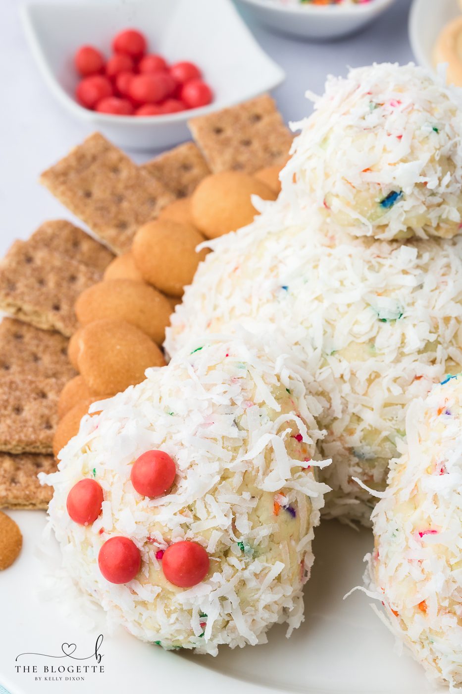 A Bunny Butt Cheeseball that is both whimsical and satisfying! Made with cream cheese, sprinkles, and fluffy layer of shredded coconut.