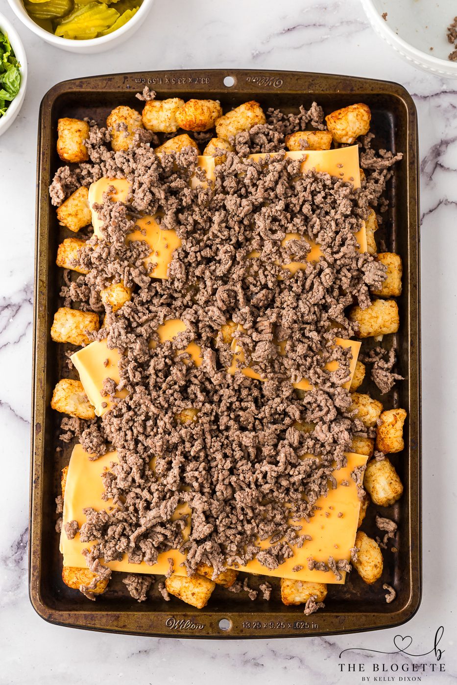 Layer ground beef over cheese and tater tots