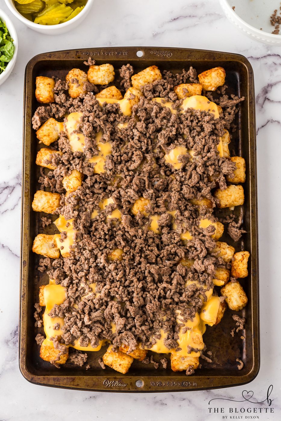 Layer ground beef over cheese and tater tots