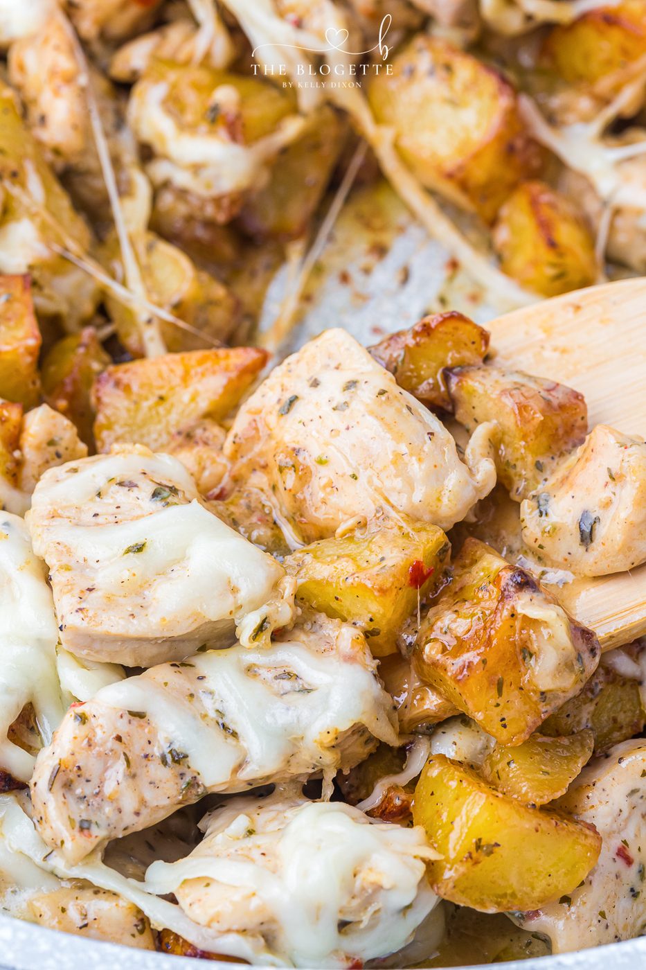 Garlic Parmesan Chicken and Potatoes recipe! A skillet with potatoes and chicken in a buttery, garlic, Parmesan sauce, topped with cheese.