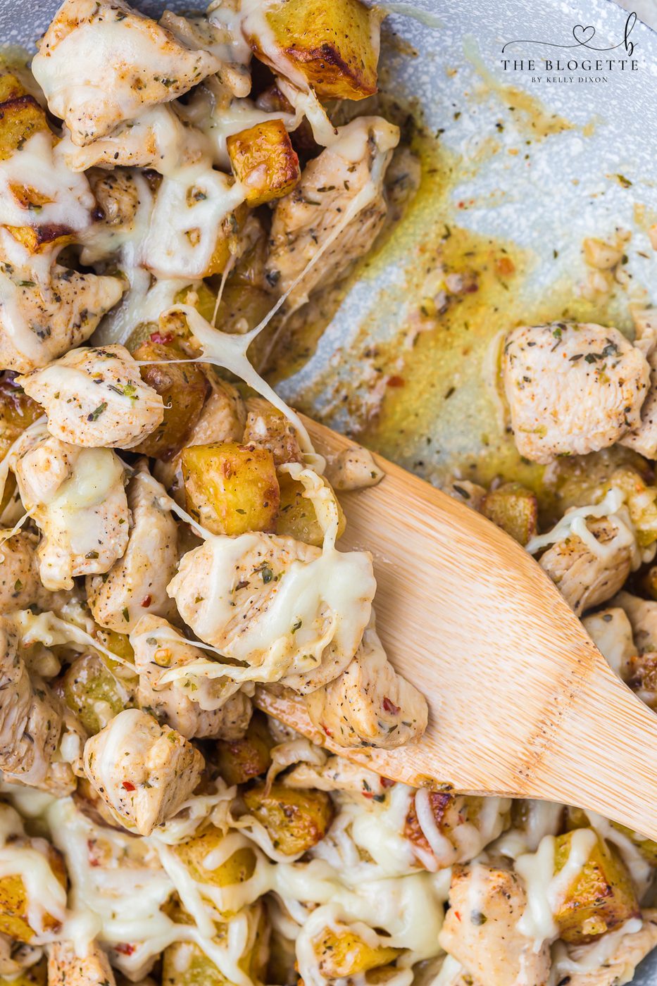 Garlic Parmesan Chicken and Potatoes recipe! A skillet with potatoes and chicken in a buttery, garlic, Parmesan sauce, topped with cheese.
