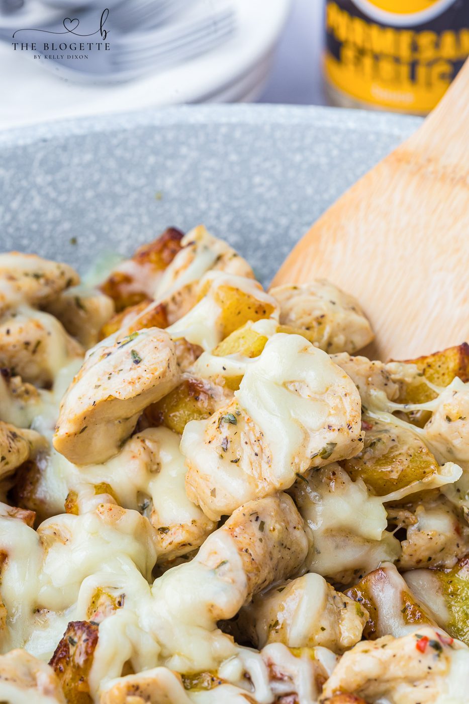 Garlic Parmesan Chicken and Potatoes recipe! A skillet with potatoes and chicken in a buttery, garlic, Parmesan sauce, topped with cheese.
