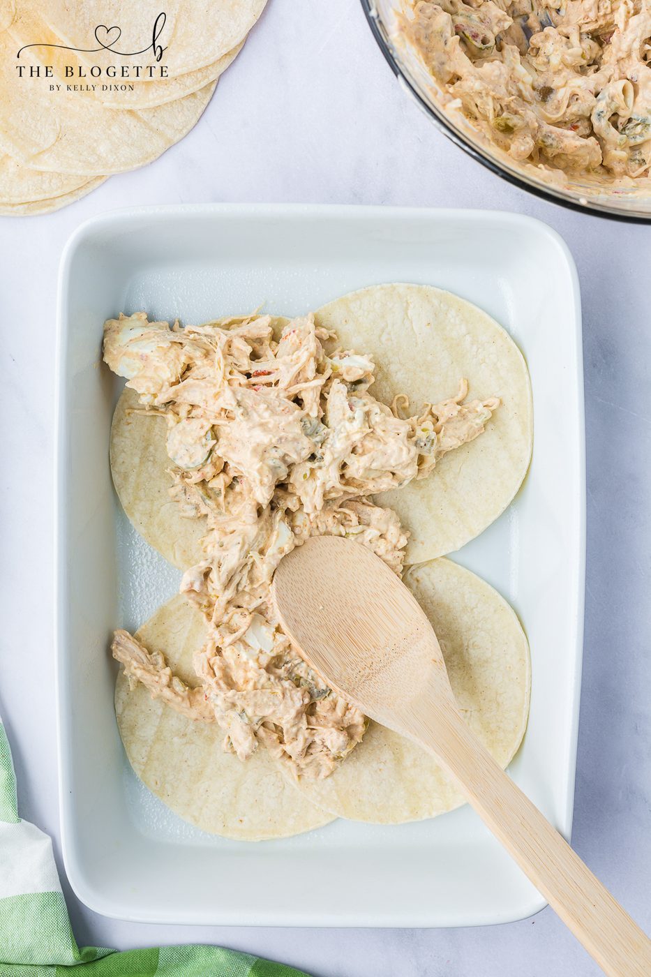 Use a spoon or spatula to spread half of the chicken mixture over the tortilla layer.
