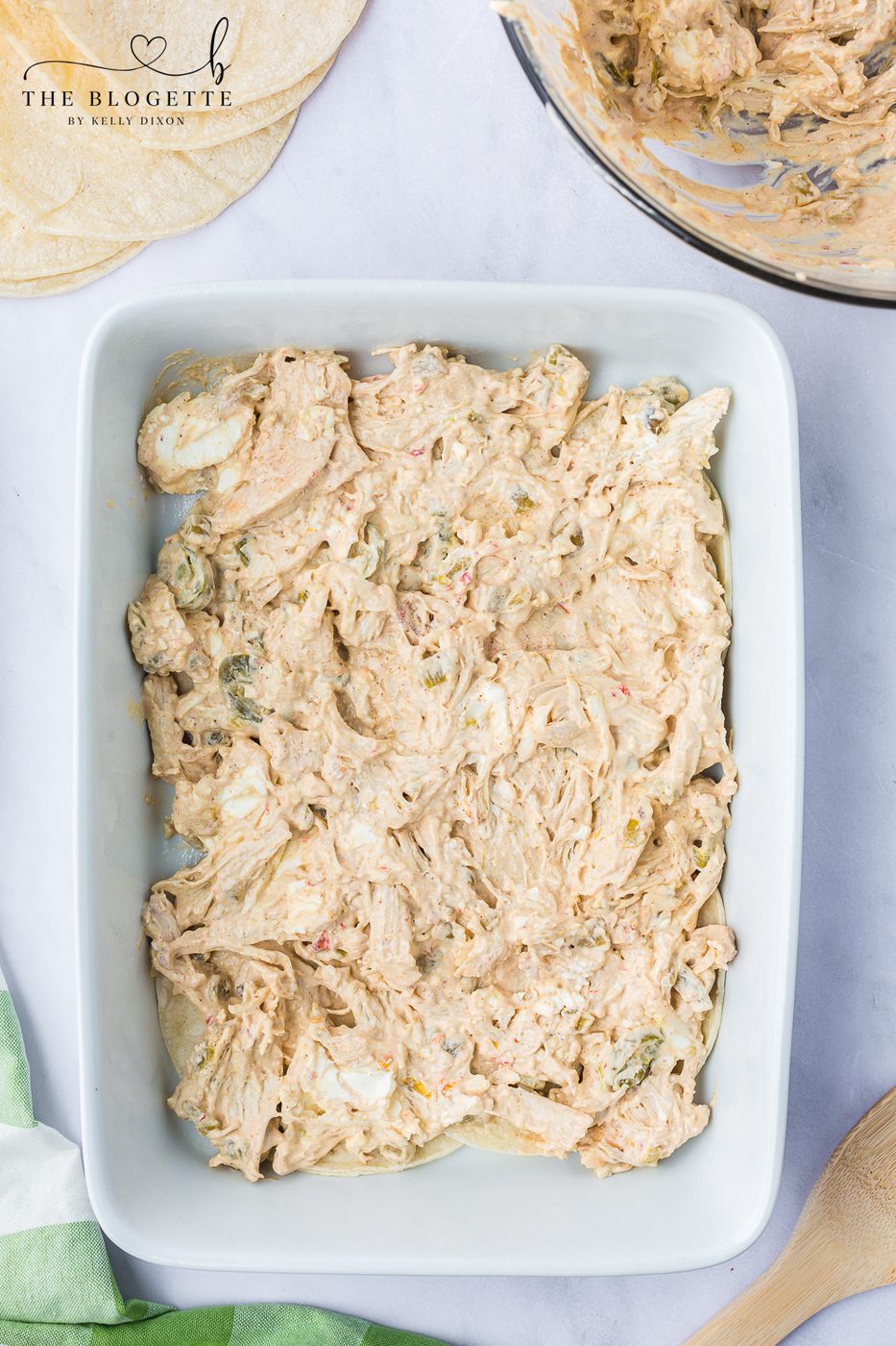 Use a spoon or spatula to spread half of the chicken mixture over the tortilla layer.
