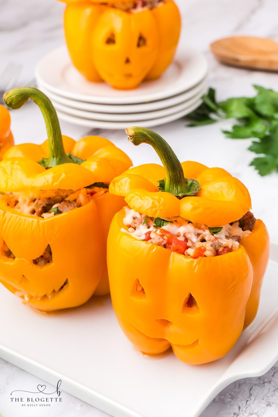 Orange bell peppers carved into jack o lantern pumpkins and stuffed with ground beef and rice for Halloween!