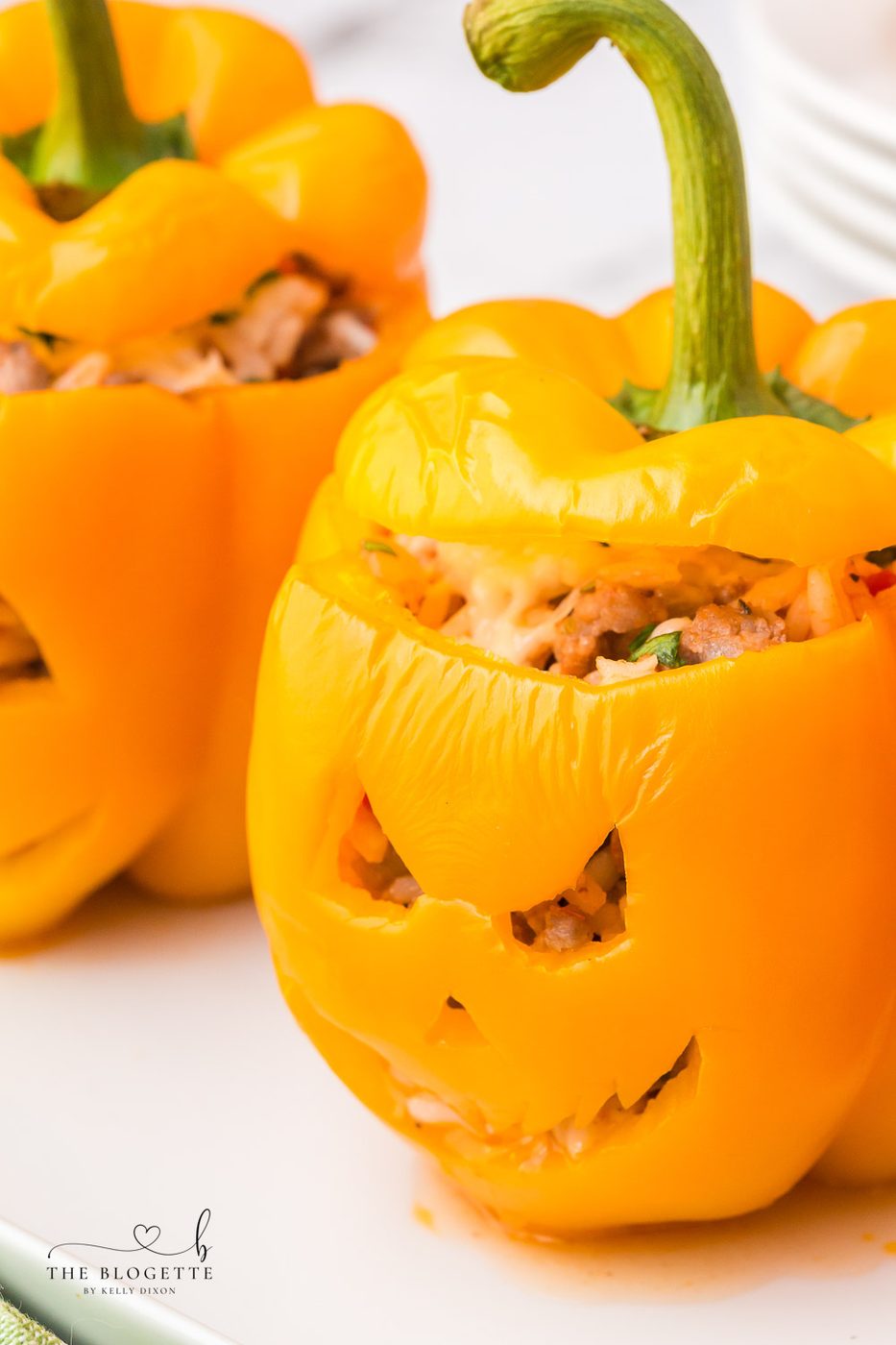 Orange bell peppers carved into jack o lantern pumpkins and stuffed with ground beef and rice for Halloween!