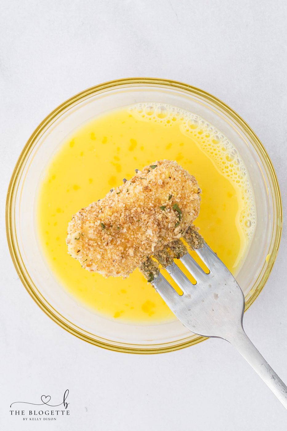 Dip the mozzarella slices in the egg