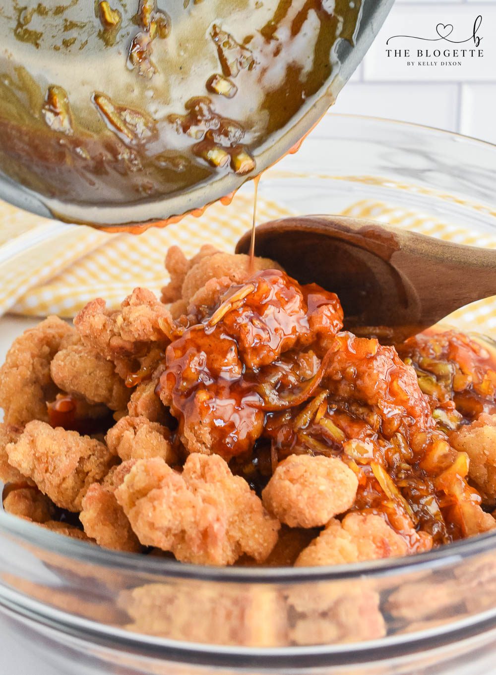 Pouring orange sauce over chicken