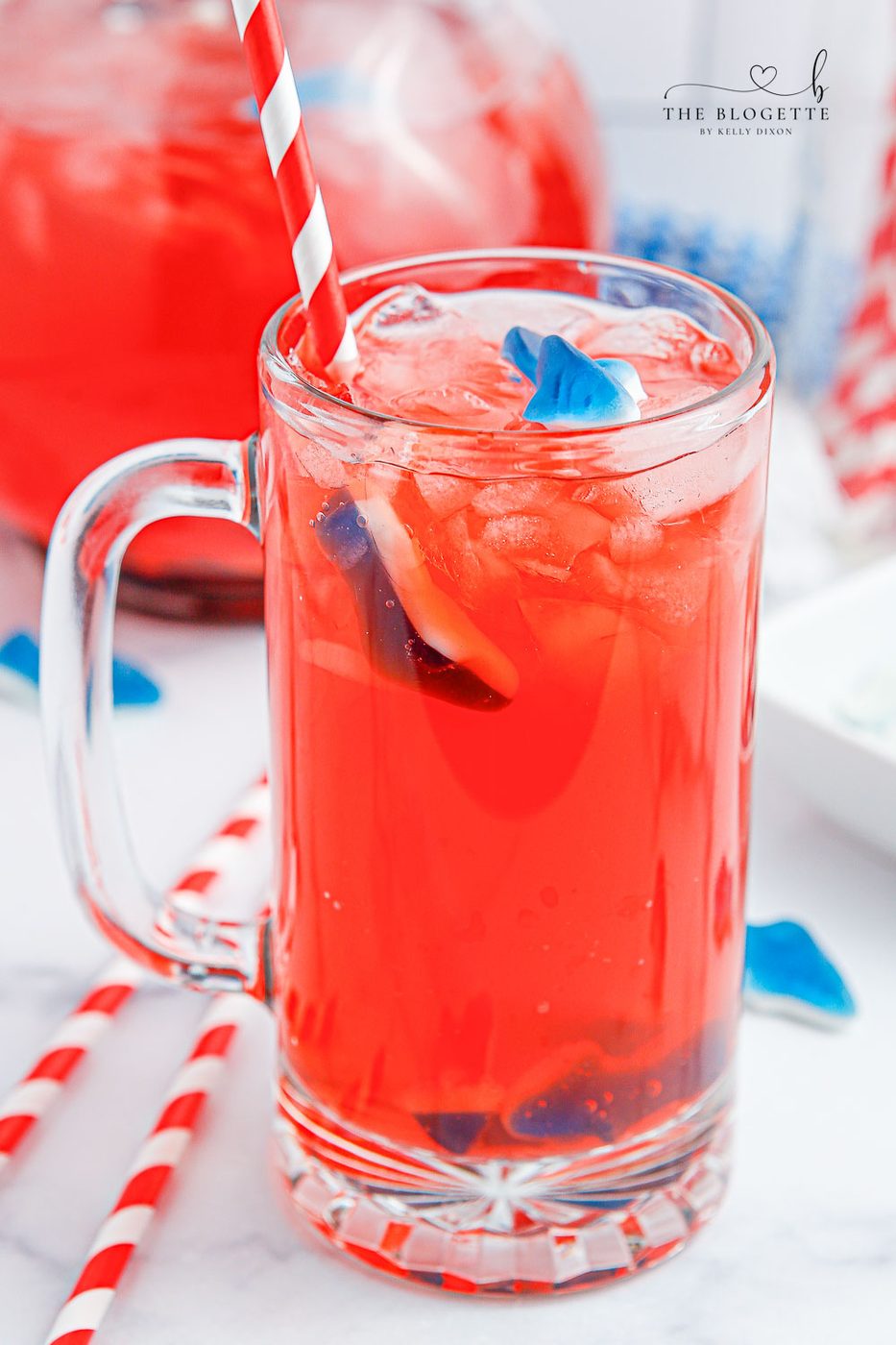 Shark Attack Punch or mocktail is the ultimate summertime drink! Tasty red punch served with floating shark gummies. Shark Punch is well-balanced for Shark Week or beach-themed parties!
