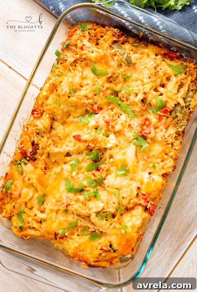 Zesty Chicken Fajita Bake 7 A close-up of a serving of cheesy chicken fajita casserole on a plate, garnished with fresh cilantro and a dollop of sour cream.