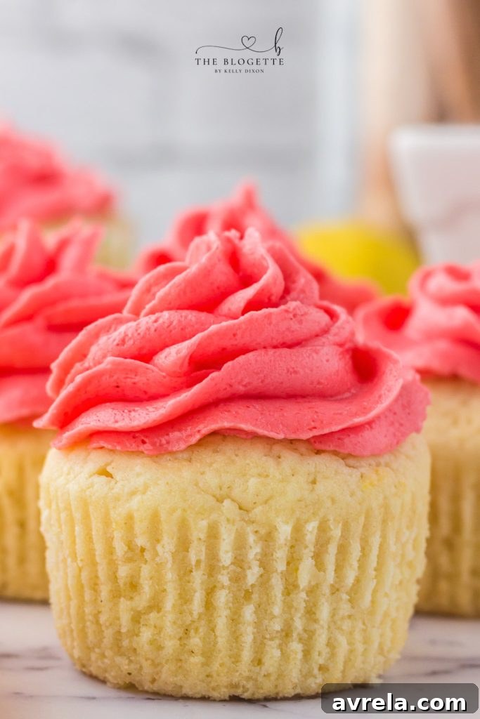 Moist and fluffy Strawberry Lemon Cupcakes topped with vibrant strawberry frosting.