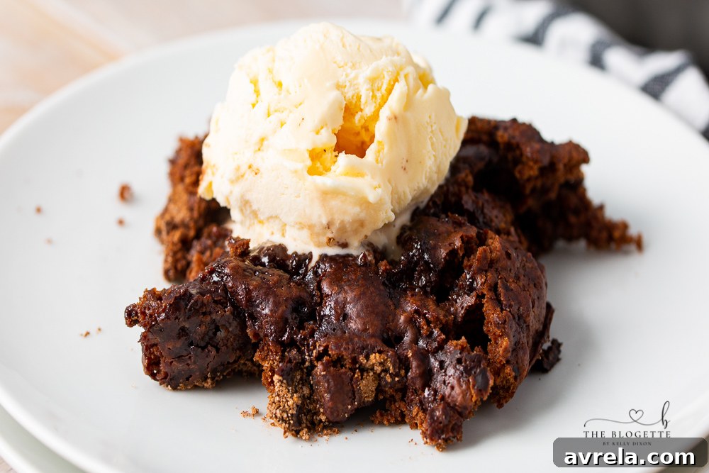 A slice of Hot Fudge Pudding Cake, warm and gooey, served on a white plate