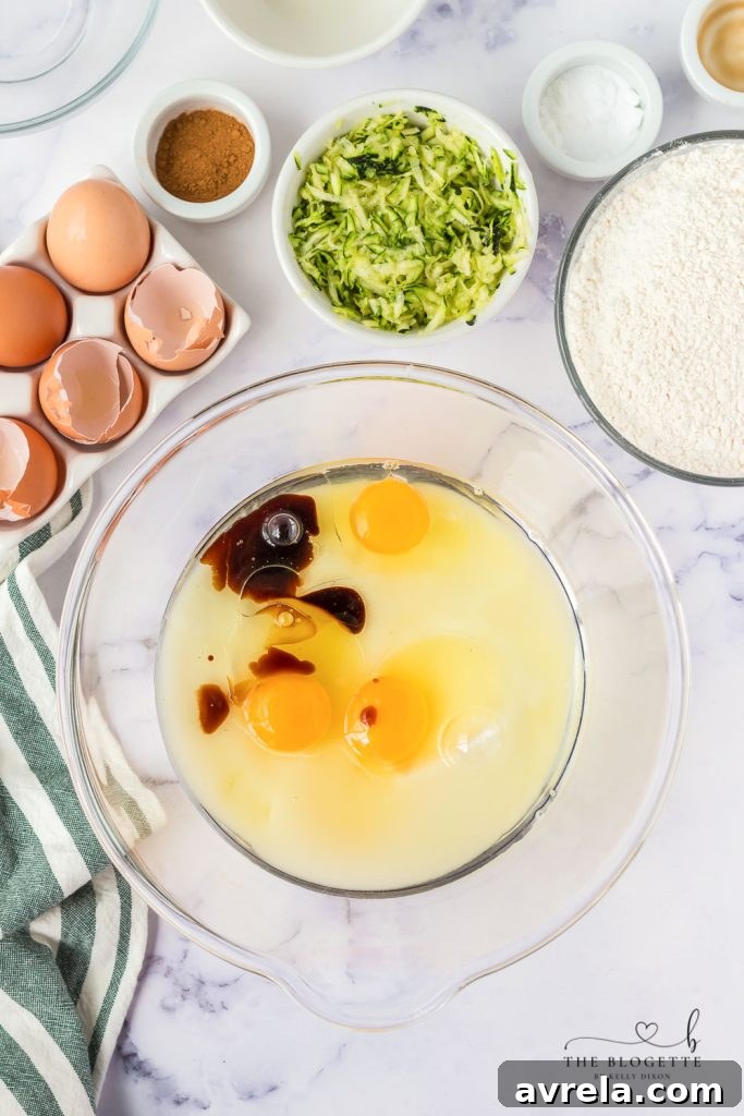 Hands mixing wet ingredients in a large bowl, a key step in preparing zucchini bread batter.