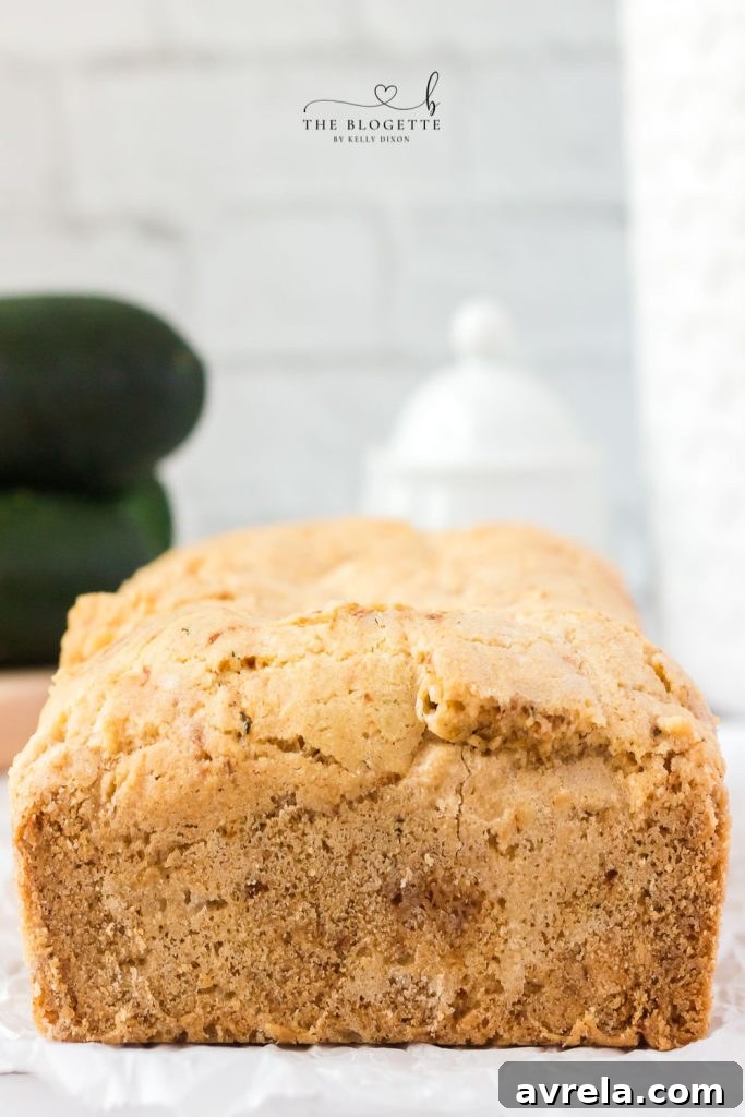 A sliced loaf of Amish Zucchini Bread displaying its moist interior and ready to be enjoyed with various toppings.