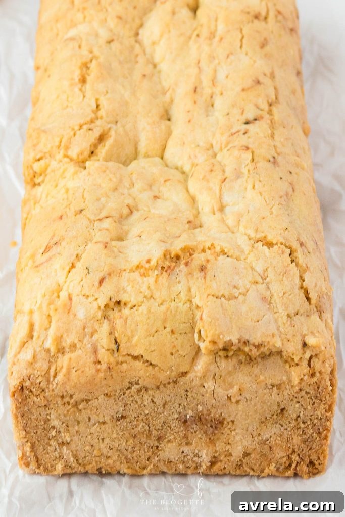 A beautifully presented Amish Zucchini Bread on a rustic cutting board, surrounded by fresh zucchini, ready to be served.