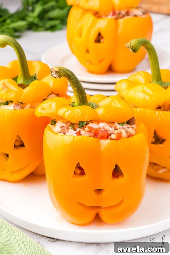 Orange bell peppers carved into jack o lantern pumpkins and stuffed with ground beef and rice for Halloween!