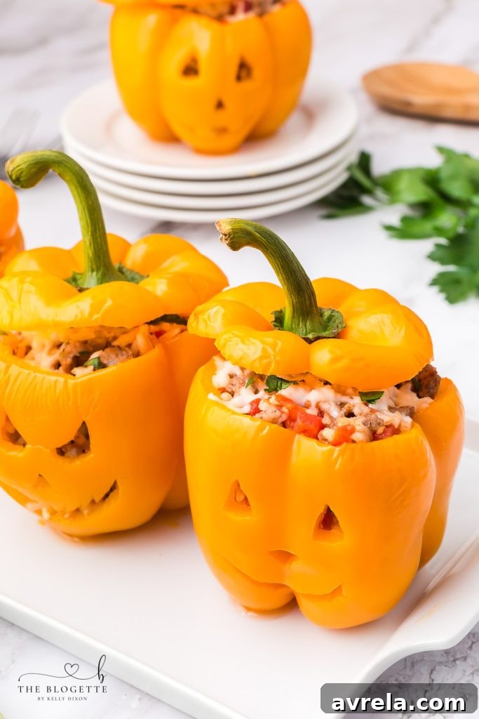 Orange bell peppers carved into jack o lantern pumpkins and stuffed with ground beef and rice for Halloween!