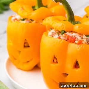 Orange bell peppers carved into jack o lantern pumpkins and stuffed with ground beef and rice for Halloween!
