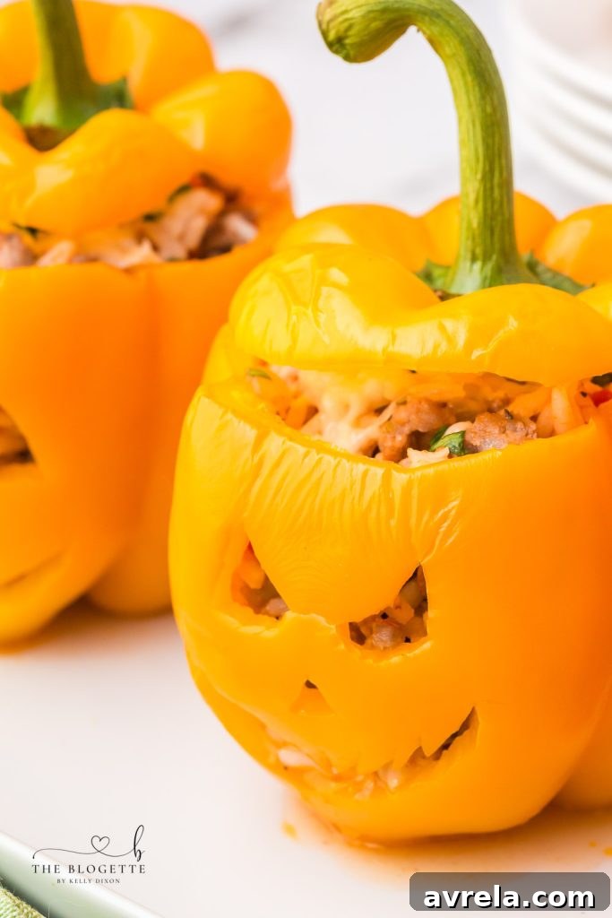 Orange bell peppers carved into jack o lantern pumpkins and stuffed with ground beef and rice for Halloween!