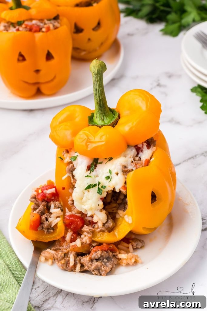Orange bell peppers carved into jack o lantern pumpkins and stuffed with ground beef and rice for Halloween!