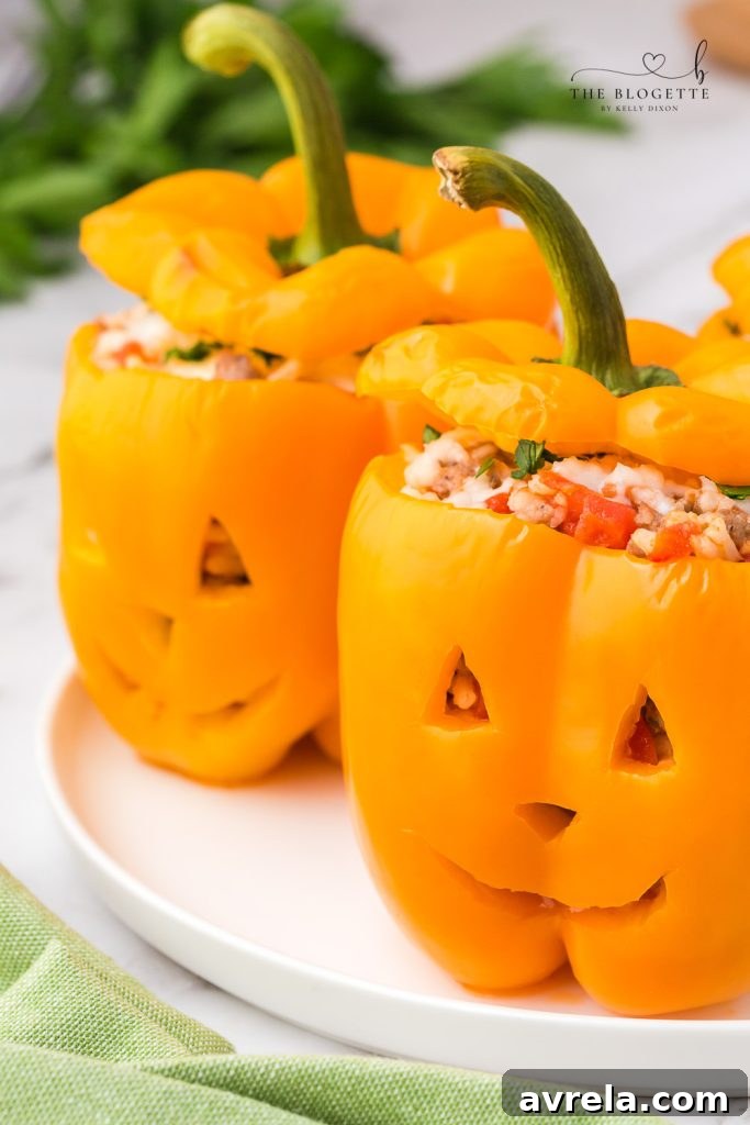 Orange bell peppers carved into jack o lantern pumpkins and stuffed with ground beef and rice for Halloween!