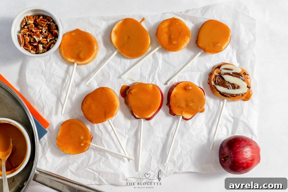 Caramel apple slices being dipped into a bowl of melted caramel.