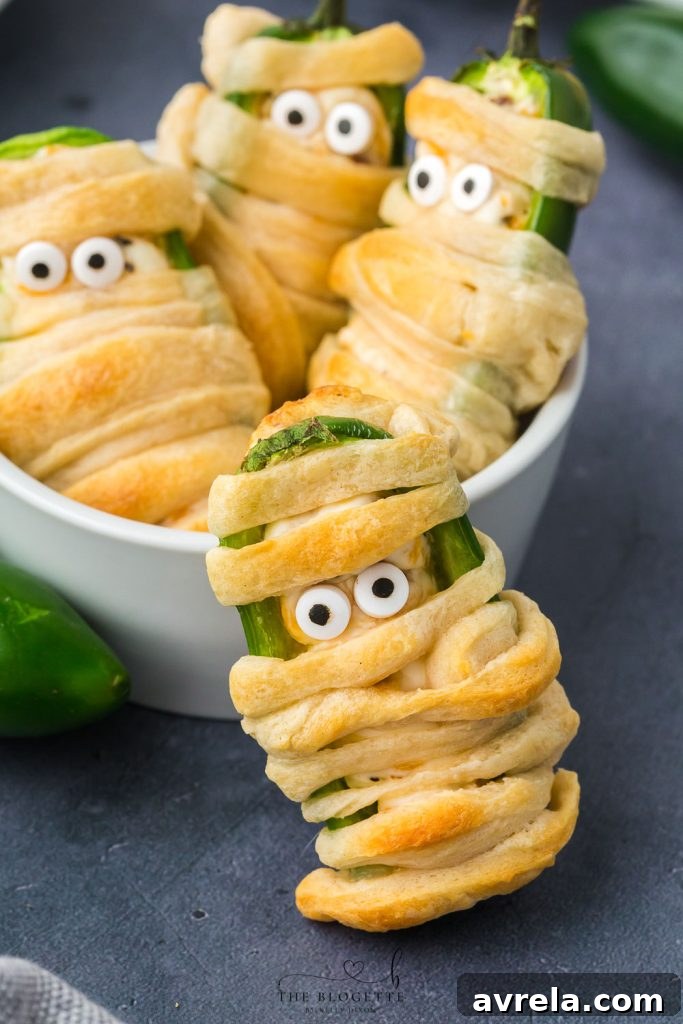 A festive spread of Halloween-themed appetizers, including Jalapeño Popper Mummies, ready for a party.
