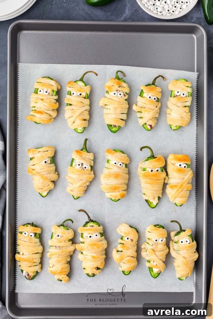 Finished Jalapeño Popper Mummies with candy eyes, served warm and ready to enjoy for Halloween.