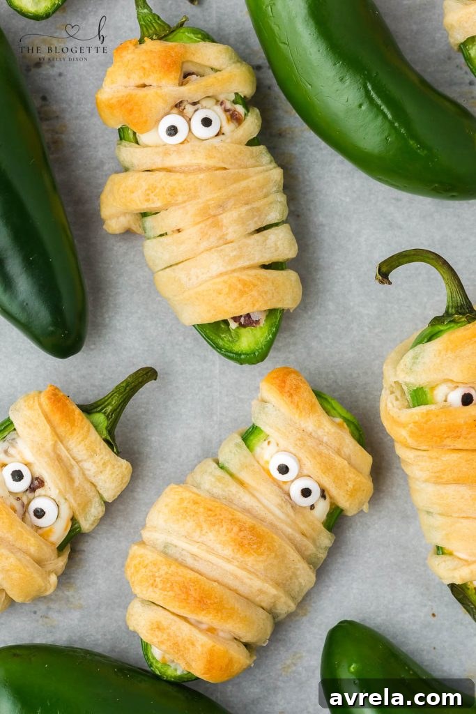 Halloween Jalapeño Popper Mummies are adorably spooky jalapeños, filled with a cream cheese mixture, wrapped in crescent dough, and baked!