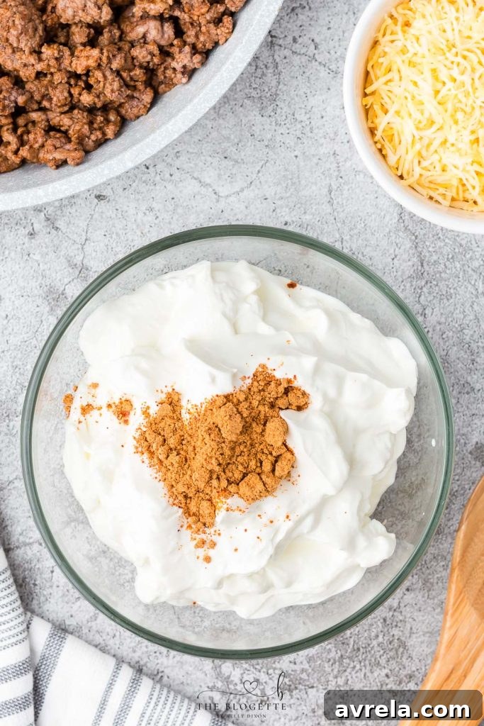 Sour cream mixed with taco seasoning, a key ingredient for a flavorful 7 layer dip.