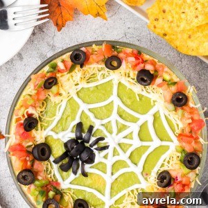 A beautifully presented Spider Web 7 Layer Dip, crowned with a spooky olive spider.