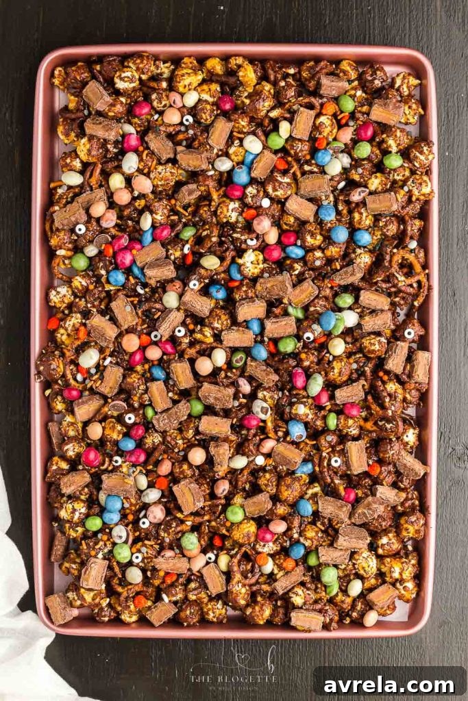 Fright Night Fuel 2 Halloween Snack Mix, a vibrant blend of chocolate caramel popcorn, pretzels, and festive candies, perfect for any Halloween party.