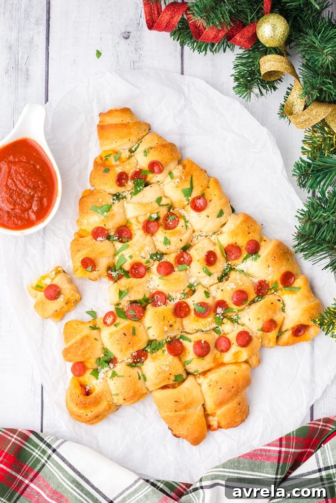 Christmas Tree Tear and Share Bread 3 A close-up of a festive Christmas Tree Pull Apart Bread, showcasing the cheesy interior and pepperoni details, a truly versatile holiday party food.