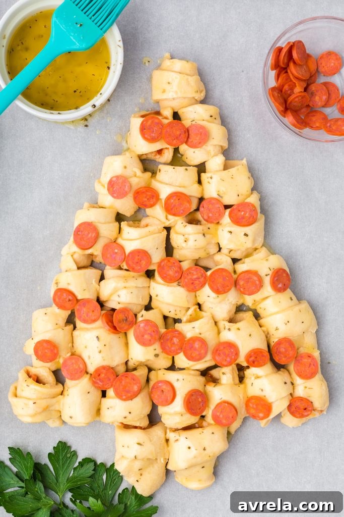 Christmas Tree Tear and Share Bread 9 The baked Christmas Tree Pull Apart Bread, adorned with pepperoni ornaments and a melted butter herb glaze, ready to be served as a holiday centerpiece.