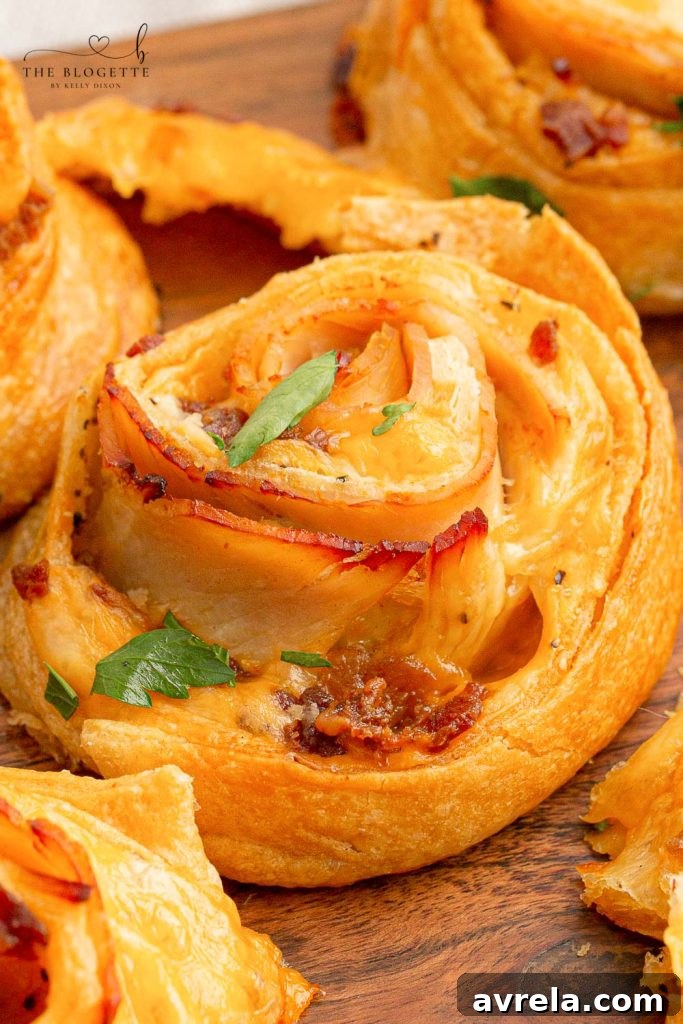 Baked Turkey and Cheese Rolls with melted cheese, bacon, and turkey, covered in a garlic buttery glaze. The perfect party appetizer idea!