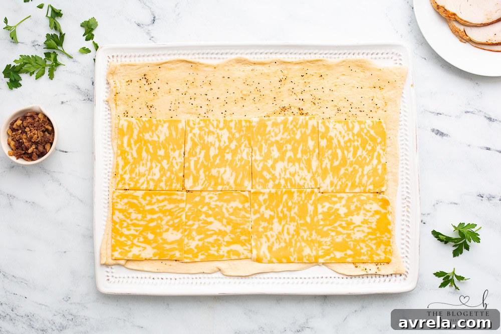 Cheese being laid out on crescent roll dough.