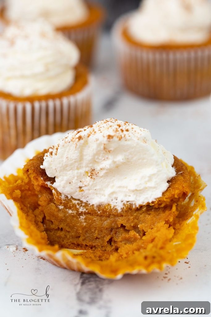 Close-up of freshly baked Pumpkin Pie Cupcakes with creamy topping, ideal for fall and holiday tables.