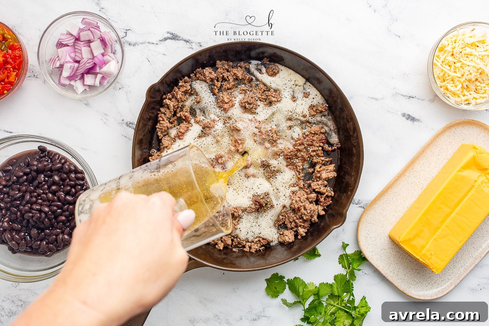 Melted cheese and pale ale simmering together with the ground beef for the queso dip.