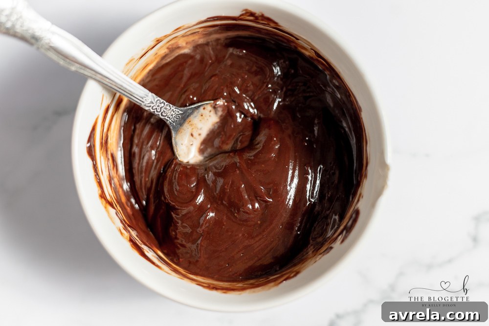 Freshly drizzled chocolate on top of peanut butter frosting on brownie bites