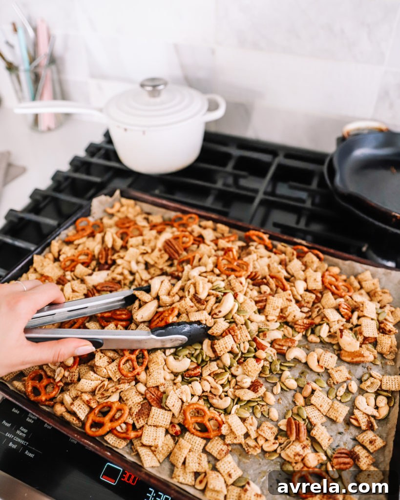 Sauce being poured over Chex Mix ingredients