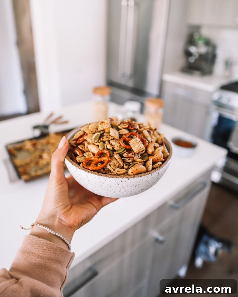 Chex Mix spread on a parchment-lined baking sheet