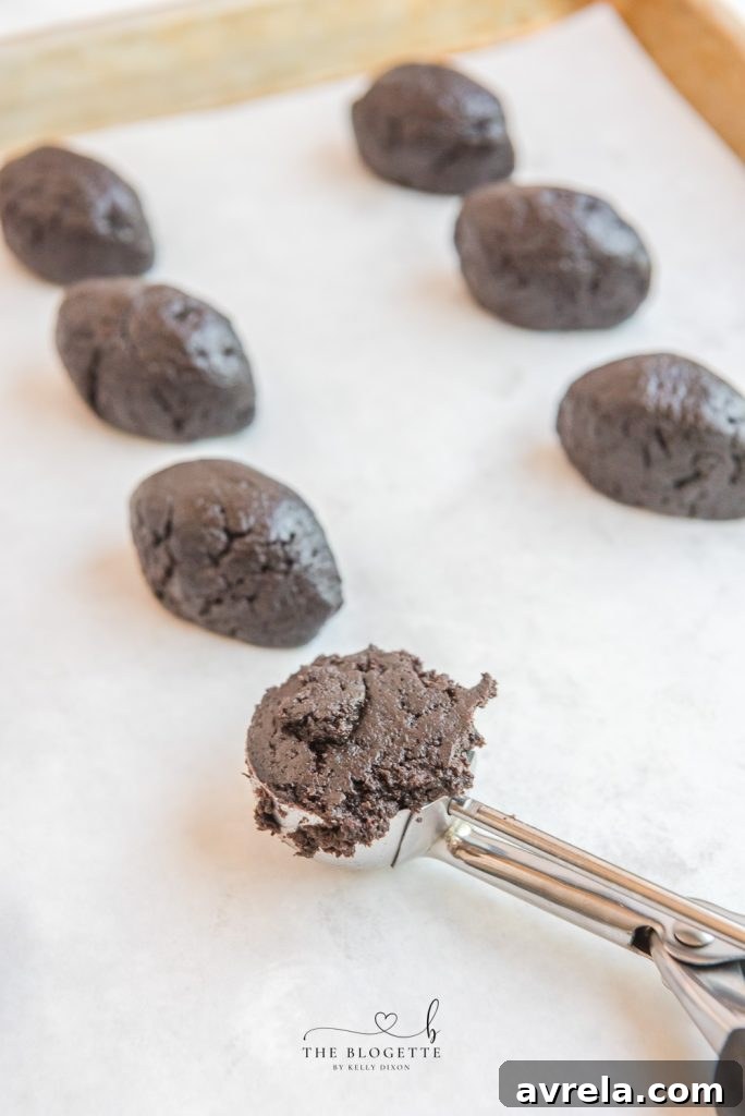 Process of shaping Oreo Truffle mixture into a football design, showing the pinching technique.