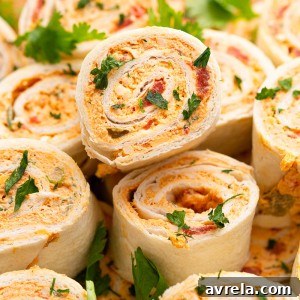 Chicken Enchilada Roll Ups are the perfect appetizer or snack for any party or occasion. This make-ahead appetizer is made with easy-to-find ingredients like taco seasoning, cream cheese, and shredded chicken (or leftover chicken!).
