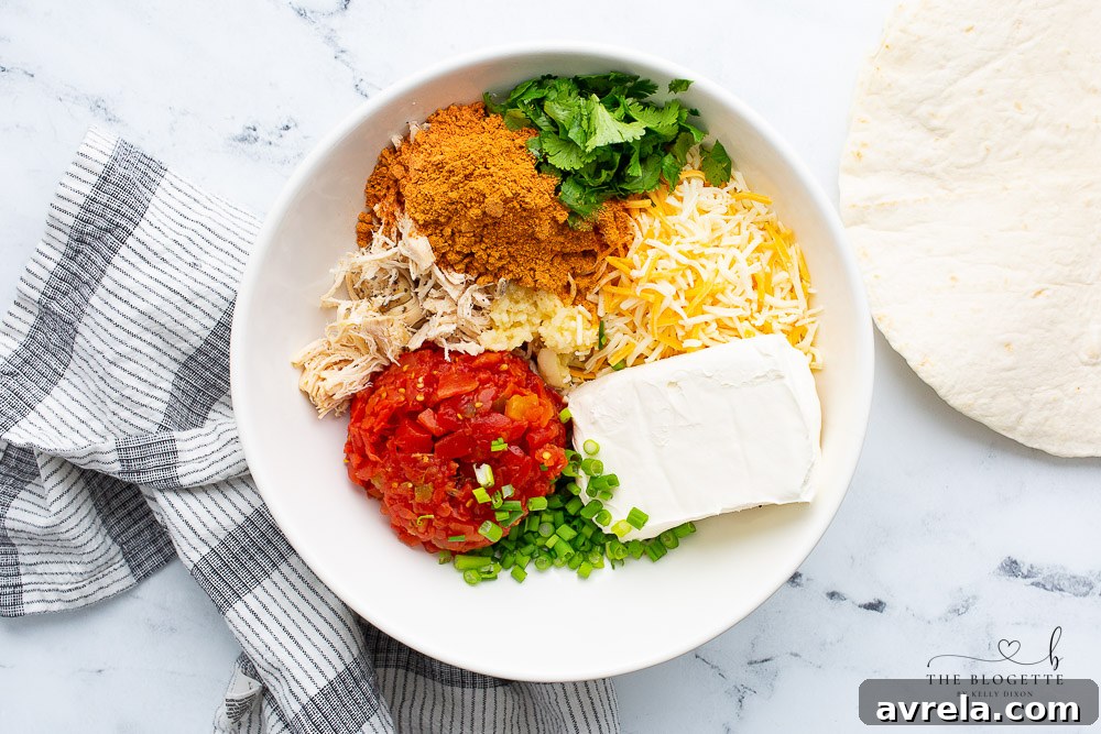 A vibrant display of all the fresh and simple ingredients needed for Chicken Enchilada Roll Ups, including tortillas, shredded chicken, cheeses, and spices.