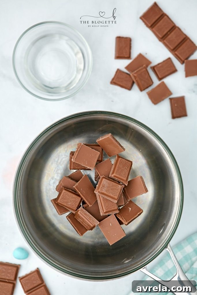 Close-up of chocolate bars broken into pieces, ready for melting to create chocolate egg nests.