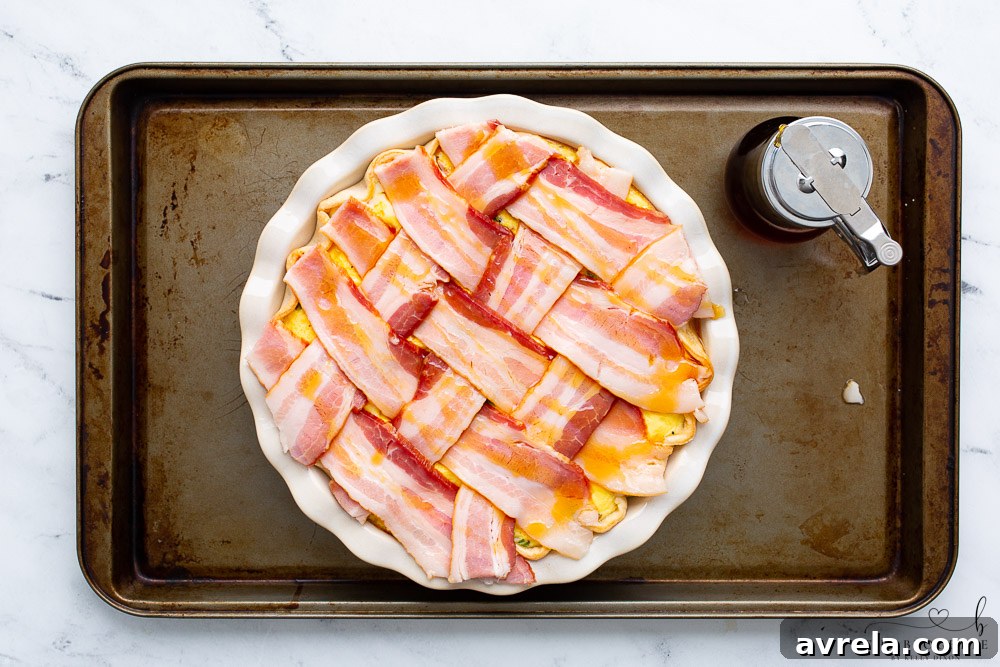 Maple Glazed Bacon Breakfast Bake 11 Maple syrup being brushed over a bacon lattice on a breakfast pie before the final baking.