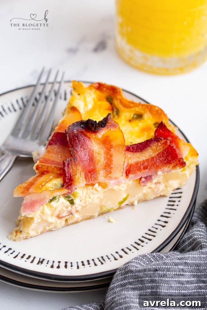 Maple Glazed Bacon Breakfast Bake 3 Close-up of a slice of Maple Bacon Breakfast Pie revealing layers of eggs, cheese, and potatoes, ready to be served.